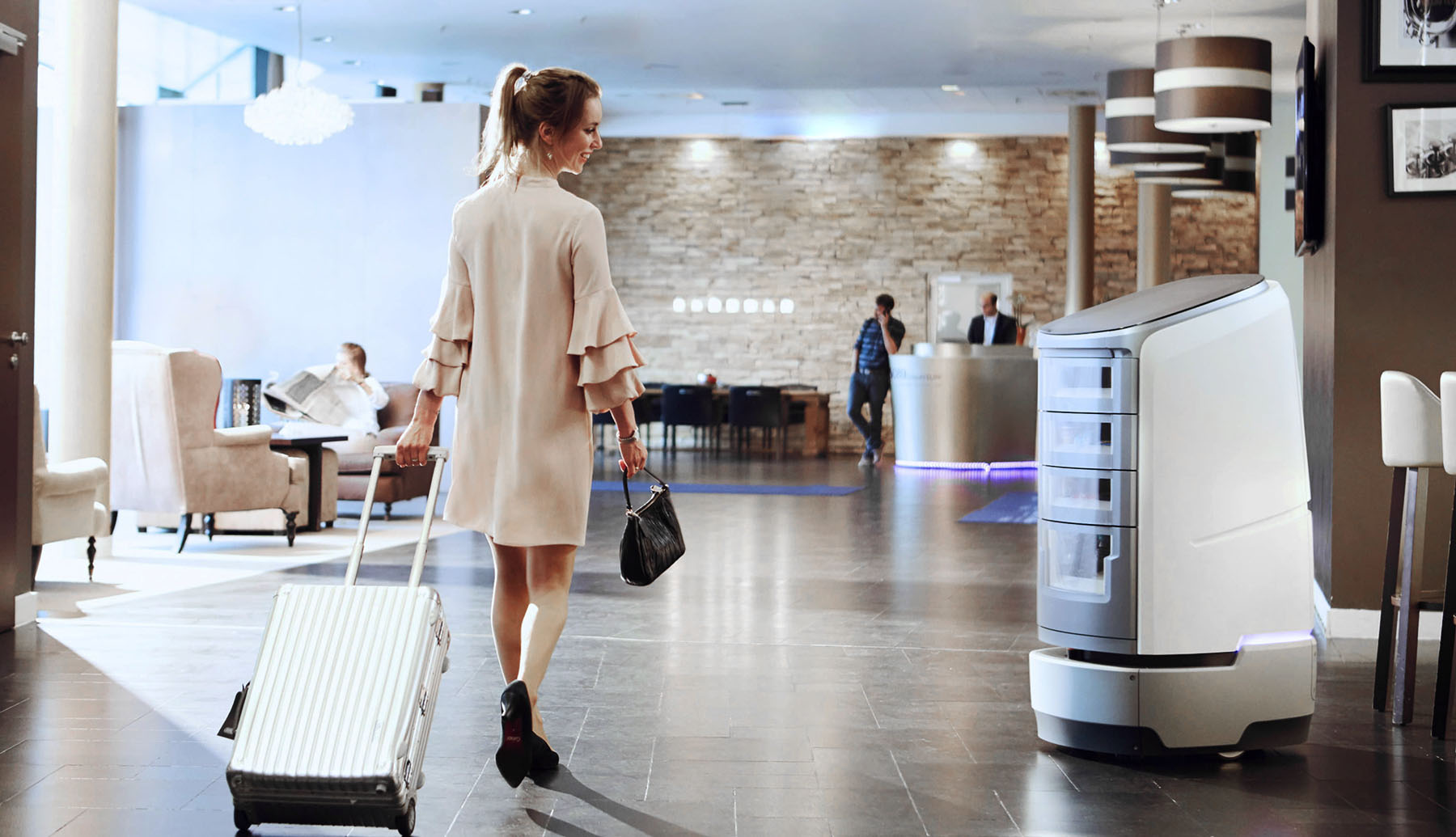 Jeeves greeding a guest in a hotel lobby