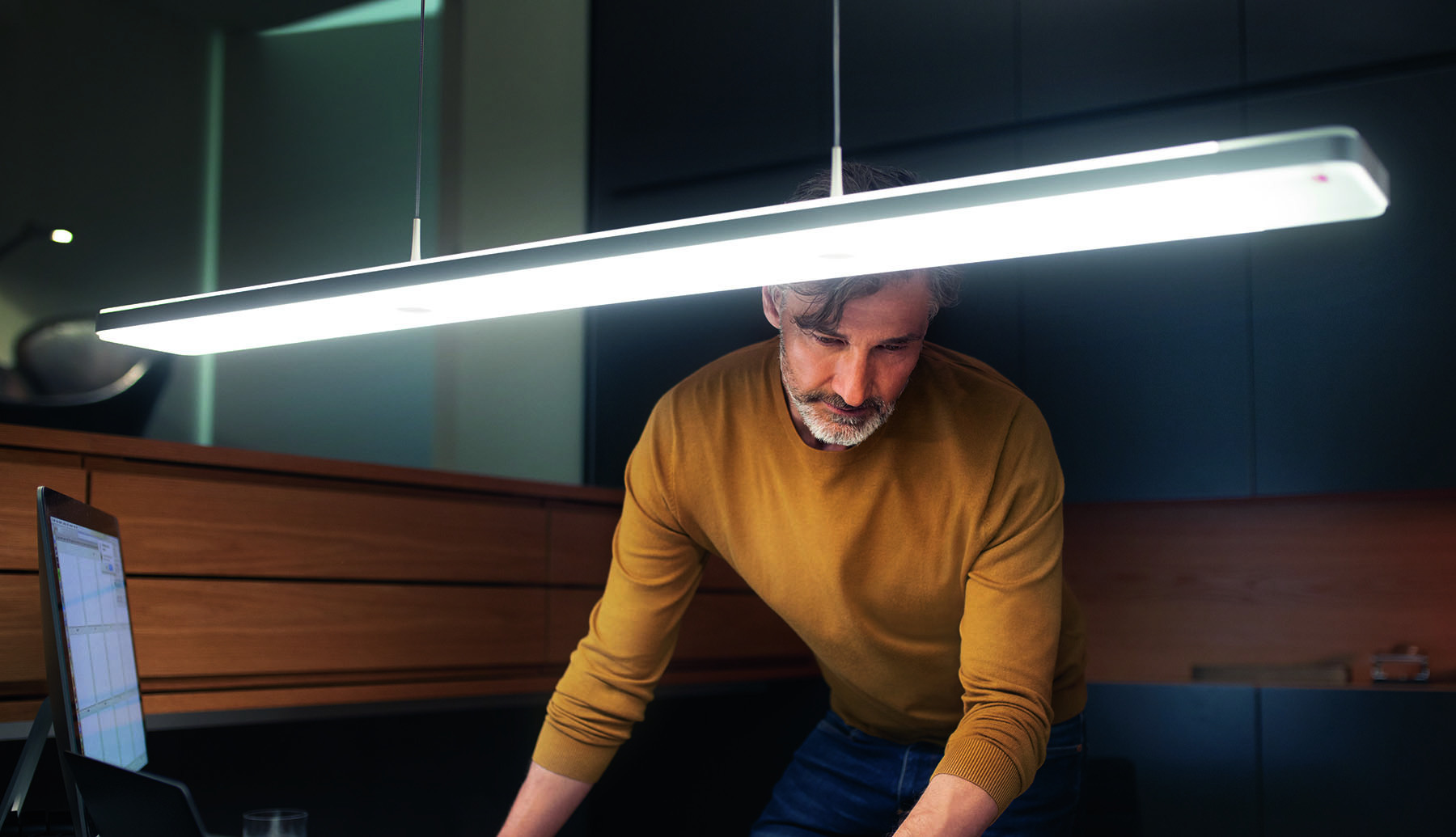 Man working underneath the Senses Touch Led pendant lamp showing the minimal design