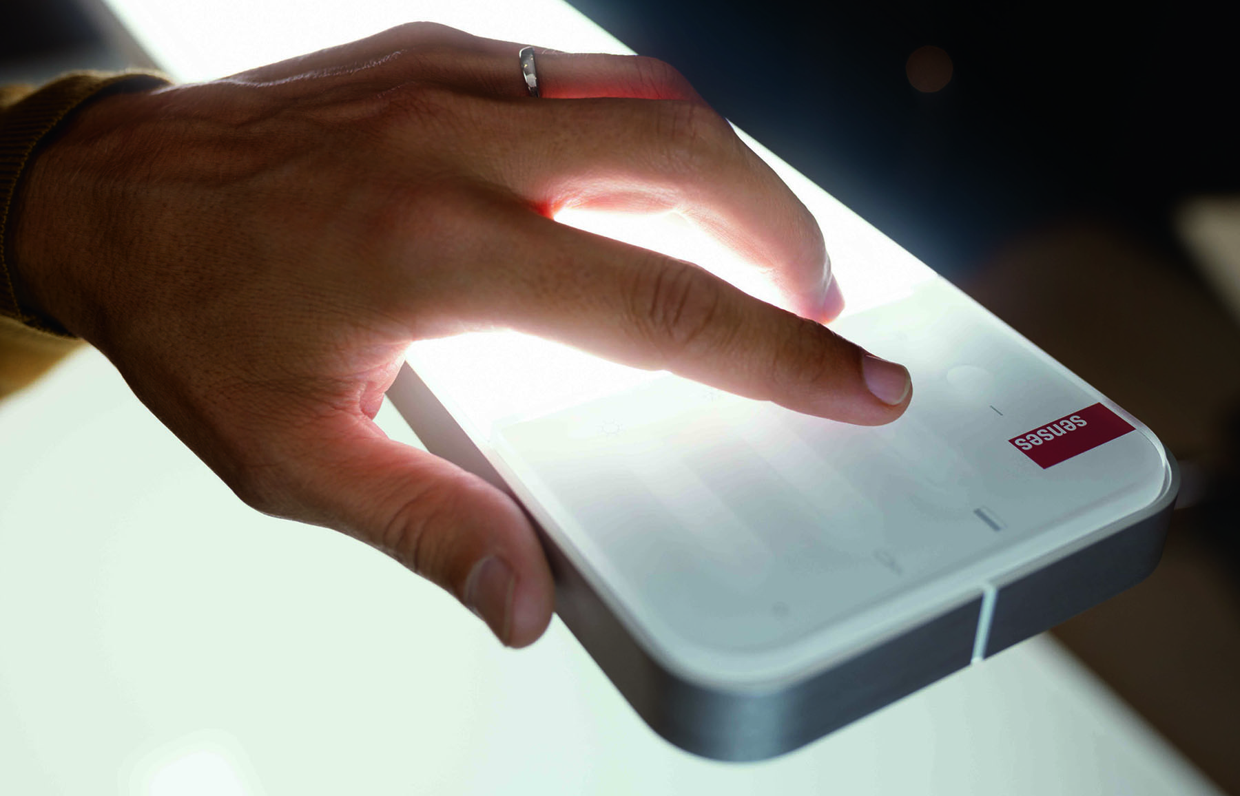 Hand using the Intuitive touch interface on the Senses Led Lamp allowing you to dim light