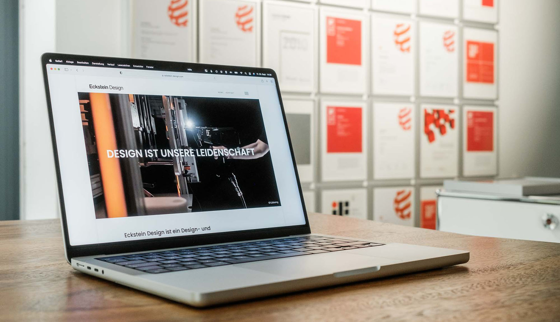 Laptop displaying the new Eckstein design Website in front of red dot and if Design awards