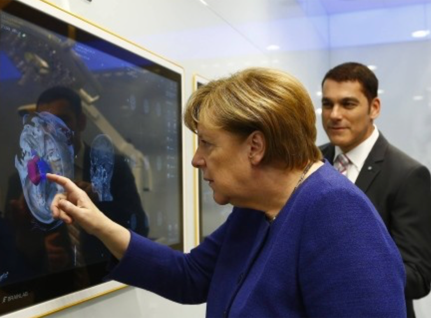 Angela Merkel interacting with the Brainlab Buzz OR monitor