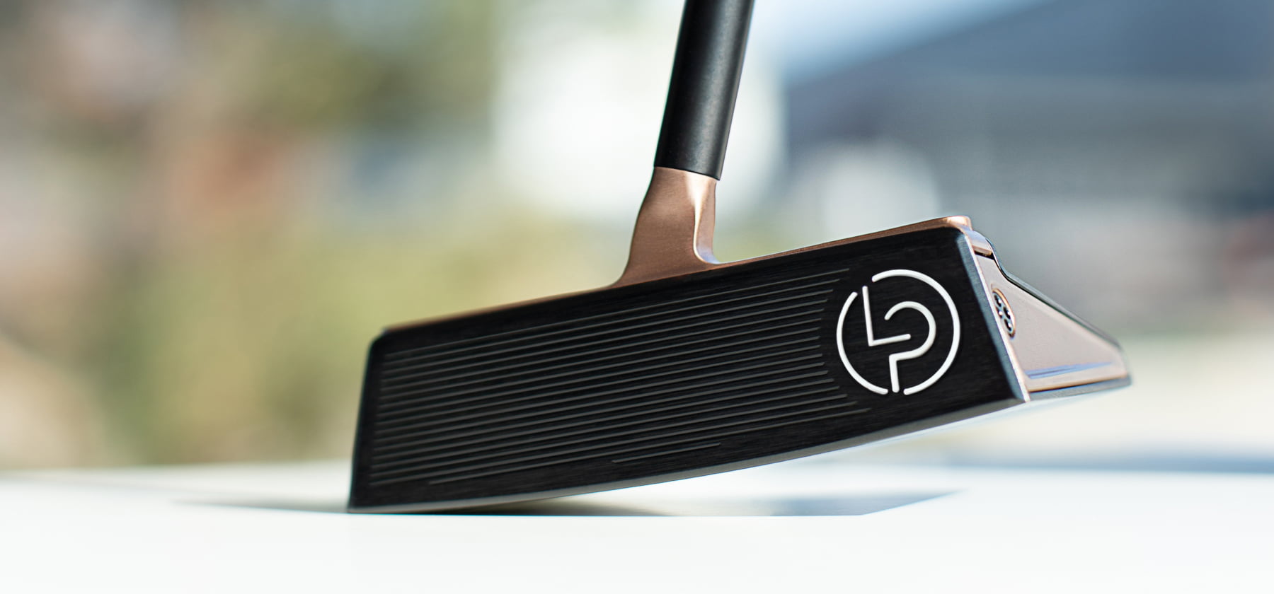 Front view of the Lubbering Petersen GROOVIN' Putter in black and gold with white logo